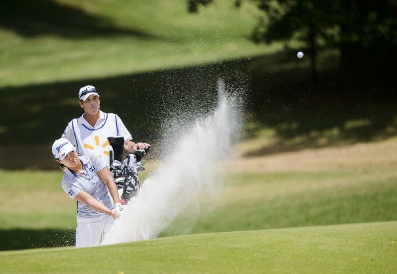 Nasa Hataoka of Japan blasts from a bunker on the seventh hole Saturday during the LPGA Northwest Arkansas Championship at Pinnacle Country Club in Rogers. Hataoka shot a 6-under 65 on Saturday and has a share of the lead entering today’s final round. 