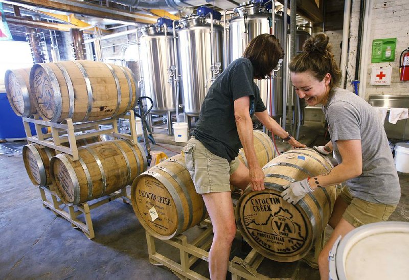 Becky Harris (left) and Addie Rodgers move a barrel of whiskey at Catoctin Creek Distillery in Purcellville, Va. which has been cultivating a European clientele. 