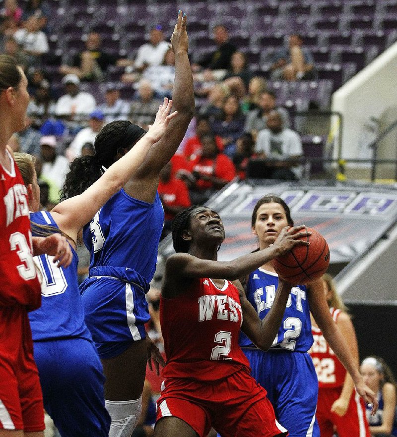 Imani Honey (center) of the West goes up for a shot over the East’s Keiunna Walker (left) during the third period of the West’s 86-79 victory in the Arkansas High School Association Girls All-Star basketball game Saturday at the University of Central Arkansas’ Farris Center in Conway. Honey, a 5-6 guard from Hot Springs, hit 6-of-9 field goal attempts and finished with 16 points and 7 rebounds. See more photos at arkansasonline.com/galleries.  
