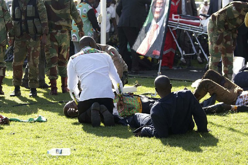 Soldiers and others help people injured Saturday in an explosion at a political rally in Bulawayo, Zimbabwe. 