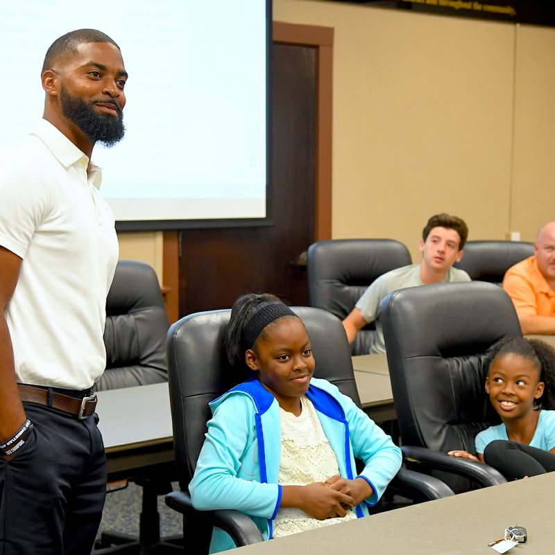 The Sentinel-Record/Grace Brown- Hot Springs World Class High School's new head football coach, Darrell Burnett, left, speaks to the school board as his wife and children look on at the Hot Springs School Dristrict's Central Office on Tuesday, June 20, 2018. 