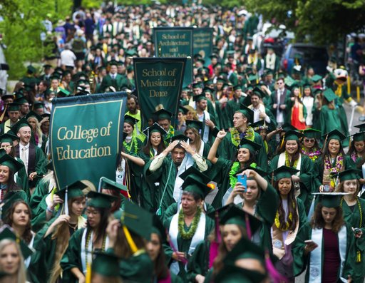 FILE- In this June 19, 2017, file photo, graduates of the University of Oregon parade down a street on campus in Eugene, Ore., on their way to a commencement ceremony in Matthew Knight Arena. The public service loan forgiveness program was created to encourage people to take jobs to help the greater good without financially crippling themselves. These positions often require higher education but pay modest wages, such as teaching, social work, public health or law enforcement. (Chris Pietsch/The Register-Guard via AP, File)