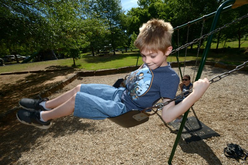NWA Democrat-Gazette/ANDY SHUPE Daniel Gibson, 8, laughs Friday while swinging on the swings with his mother, Amanda Griffith of Fayetteville at Wilson Park in Fayetteville. The Fayetteville Parks and Recreation Department has finished the first round of surveys for its Imagine Tomorrow&#180;s Parks campaign, and is gearing up for a second round of input from the public. According to the survey, Wilson Park is the residents' favorite and most visited park.