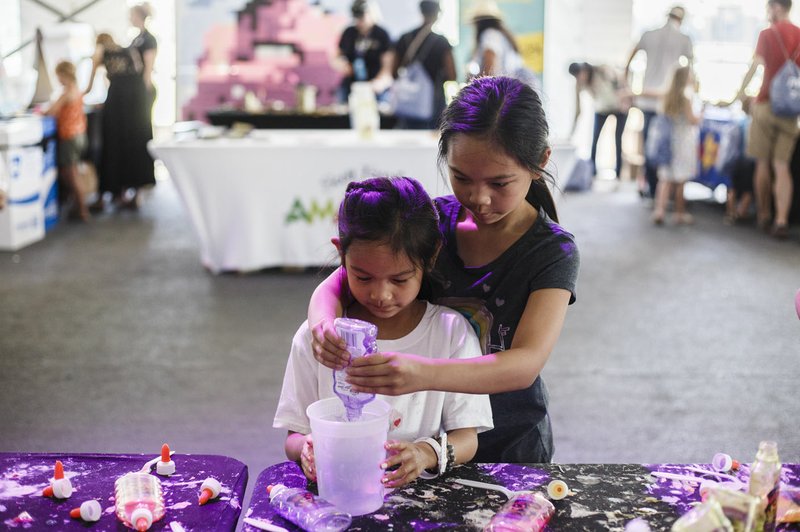 NWA Democrat-Gazette/CHARLIE KAIJO Malasy Sakounlaphoum (from right), 11, and Kantali Sakounlaphoum, 6, of Overland Park, Kan., make slime Saturday during the second round of the Walmart NW Arkansas Championship at the Pinnacle Country Club in Rogers. LPGA has a STEAM (S-Science, T-Technology, E-Amazeum, A-Art with Paper Towel Murals, M-Mathematics) focus this year with hands-on experience at the new STEAM Center tent on the 16th green at Pinnacle Country Club.