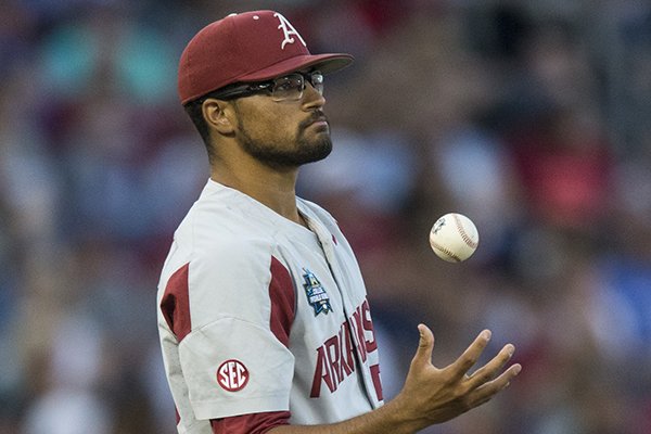 Arkansas pitcher Isaiah Campbell tosses the ball to himself during a College World Series game against Florida on Friday, June 22, 2018, in Omaha, Neb.