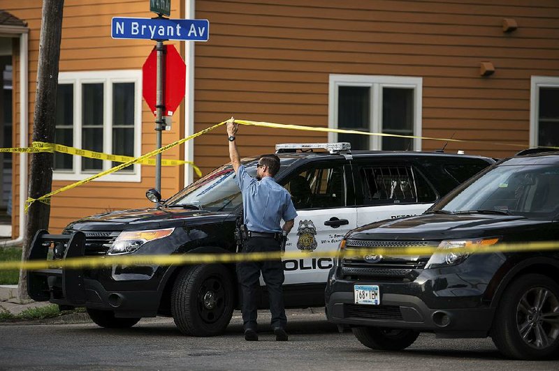 Police investigate the scene of an officer-involved shooting Saturday, in Minneapolis.  