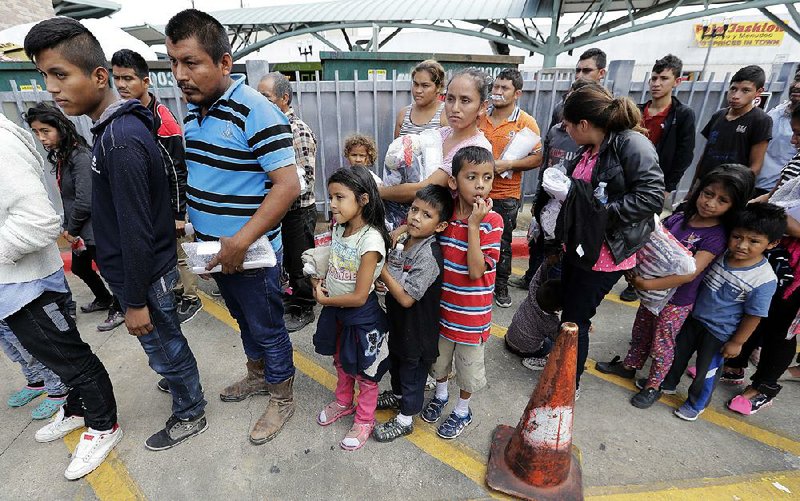 Immigrant families line up to enter the central bus station after they were processed and released by U.S. Customs and Border Protection on Sunday in McAllen, Texas.  