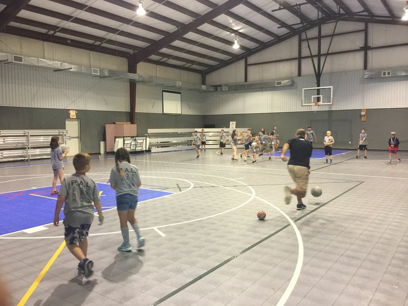 NWA DEMOCRAT-GAZETTE/TRACY M. NEAL Participants in the Benton County Sheriff's Office's PAL program's junior police academy play dodge ball Friday with deputies and volunteers. The children spent the five days of the academy learning about law enforcement and their job.