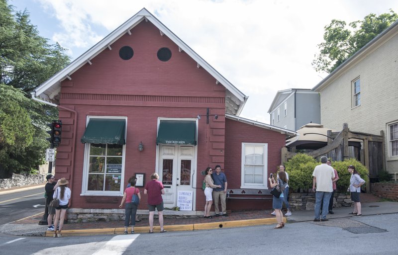 Passersby gather to take photos in front of the Red Hen Restaurant, Saturday, June 23, 2018, in Lexington, Va. White House press secretary Sarah Huckabee Sanders said Saturday in a tweet that she was booted from the Virginia restaurant because she works for President Donald Trump. Sanders said she was told by the owner of The Red Hen that she had to "leave because I work for @POTUS and I politely left." (AP Photo/Daniel Lin)

