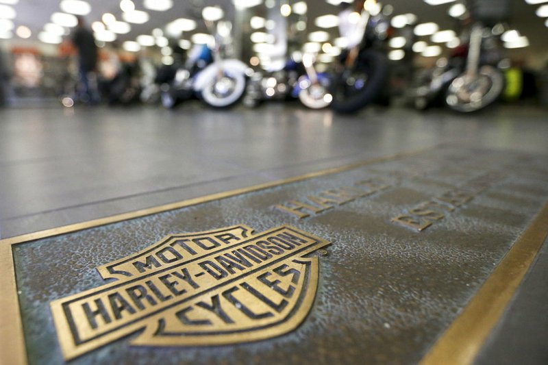 In this April 26, 2017, file photo, rows of motorcycles are behind a bronze plate with corporate information on the showroom floor at a Harley-Davidson dealership in Glenshaw, Pa. Harley-Davidson, facing rising costs from new tariffs, will begin shifting the production of motorcycles heading for Europe from the U.S. to factories overseas. (AP Photo/Keith Srakocic, File)