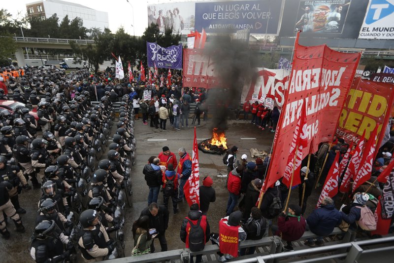 Police stand guard where striking protesters block a road the leads to the city from the south, in Buenos Aires, Argentina, Monday, June 25, 2018. (AP Photo Jorge Saenz)