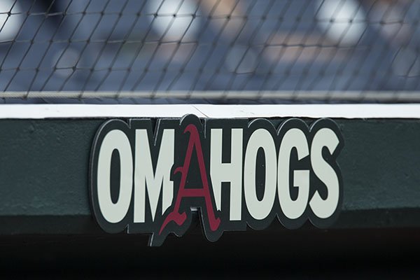 An "Omahogs" sign hangs above the Arkansas dugout prior to a College World Series game against Texas on Sunday, June 17, 2018, in Omaha, Neb.
