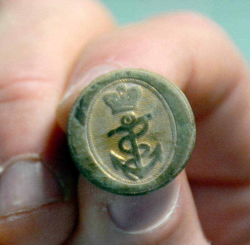 Janelle Jessen/Herald-Leader Chris Salley holds a British Royal Navy captain's button from the War of 1812 that he found in a field in southwest Missouri, just north of Pea Ridge.