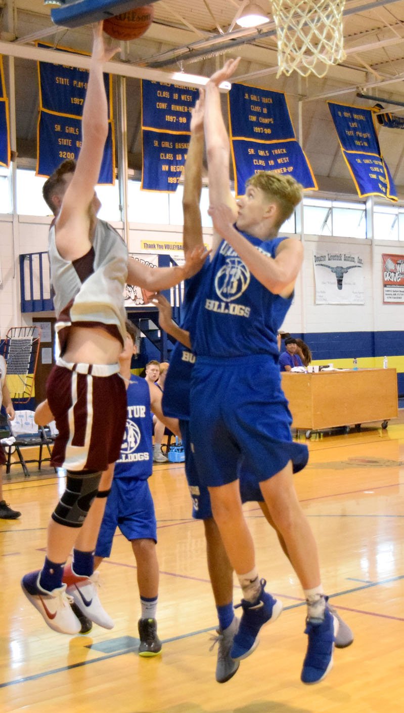 Westside Eagle Observer/MIKE ECKELS Ryan Ross (Decatur 3) tries to block a Pioneer player's jump shot during the Decatur-Gentry scrimmage game at Peterson Gym in Decatur June 19. In spite of Ross' best efforts, the shot found its mark for another two, contributing to Gentry's 26-20 win over Decatur.