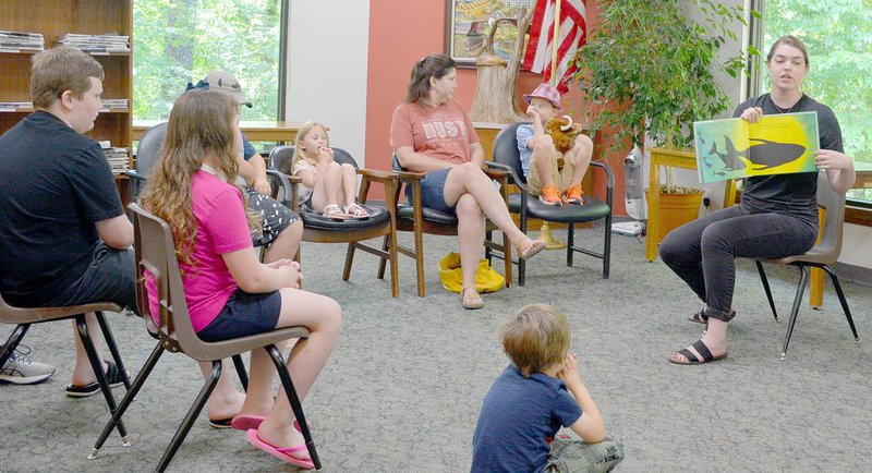 Keith Bryant/The Weekly Vista Museum of Native American History programming assistant Elyse Partee (right), shows a colorful page in the book to children who came for the Summer Reading Series' first event this summer, where Partee read stories and focused on natural sounds, which she said had a strong influence on Native American music.