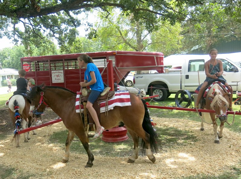 Westside Eagle Observer/SUSAN HOLLAND Youngsters will enjoy taking rides on the well-groomed mounts provided by Partytime Ponies at this Saturday's Independence Day celebration in the Sulphur Springs park. Camel rides, inflatables, duck races, a dunk tank and a kids' fishing derby are also a part of the popular annual event.