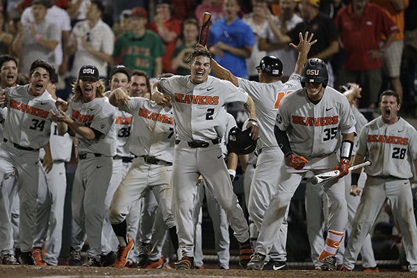 Oregon State's Cadyn Grenier (2) and Adley Rutschman (35) celebrate with teammates after Trevor Larnach hit a two-run home run against Arkansas that scored Grenier during the ninth inning of Game 2 of the NCAA College World Series baseball finals in Omaha, Neb., Wednesday, June 27, 2018. Oregon State won 5-3. (AP Photo/Nati Harnik)

