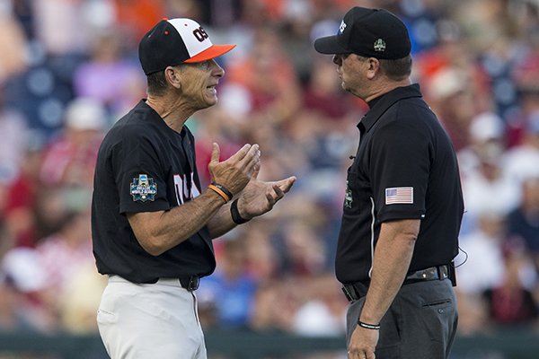 Oregon State coach Pat Casey, left, argues with second base umpire Chris Coskey during the fourth inning of a College World Series finals game against Arkansas on Tuesday, June 26, 2018, in Omaha, Neb.