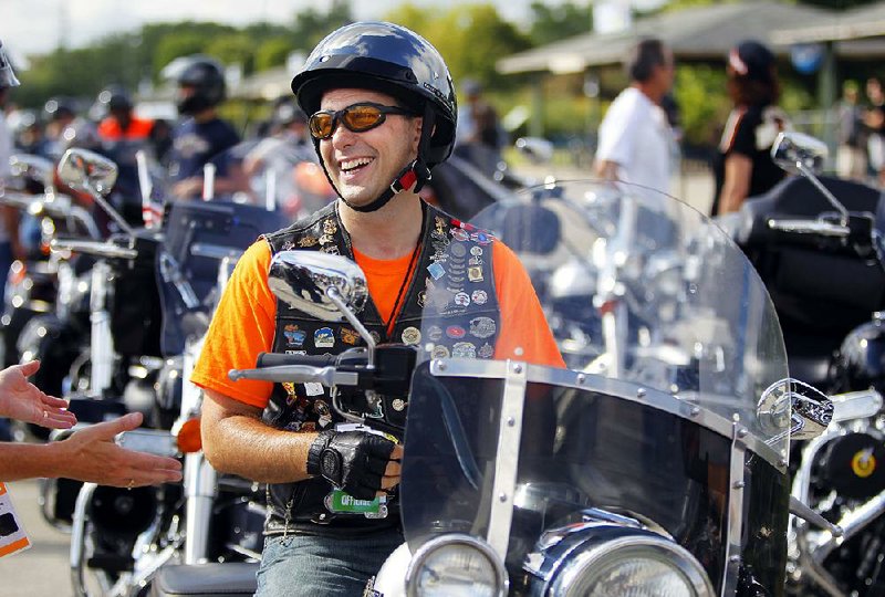 Wisconsin Gov. Scott Walker waits for the start of the parade in Milwaukee celebrating Harley-Davidson’s 110th anniversary in 2013. President Donald Trump will meet with Walker on a visit to the state this week.  