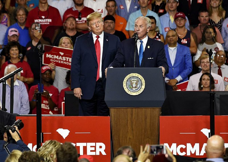 South Carolina Gov. Henry McMaster, with President Donald Trump by his side, speaks Monday to a crowd in West Columbia, S.C.  