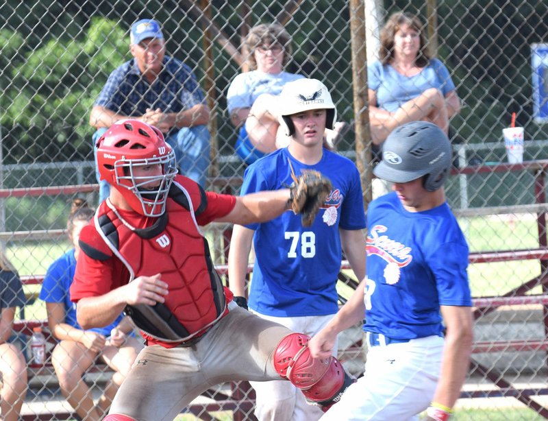 Rick Peck/Special to McDonald County Press McDonald County catcher Joe Brown reaches in an attempt to tag a Seneca runner in the McDonald County 18U baseball team's 14-2 win over Seneca on June 19 in Seneca.
