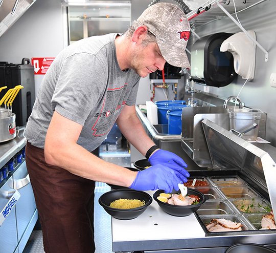 The Sentinel-Record/Grace Brown FROM THE HEART: Chef Coby Smith prepares a Japanese pork loin ramen bowl on Thursday in Arkansas Heart Hospital's food truck, Food From the Heart, which made its Hot Springs debut at the hospital's clinic located at 149 Section Line Road. The food truck will travel the state of Arkansas, hitting each of the hospital's nine locations, and will also make stops at community events throughout the year.