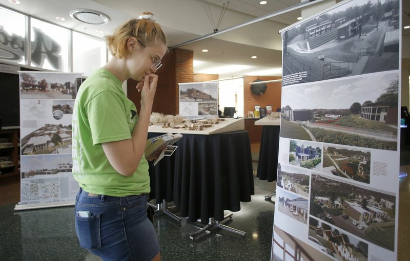 NWA Democrat-Gazette/DAVID GOTTSCHALK Joy Gilbert of Fayetteville looks Wednesday at the University of Arkansas' Community Design Center's livability plan for Willow Heights, a public housing apartment complex near downtown, on display at the Fayetteville Public Library. Models of the center's plan includes facade improvement and landscaping.