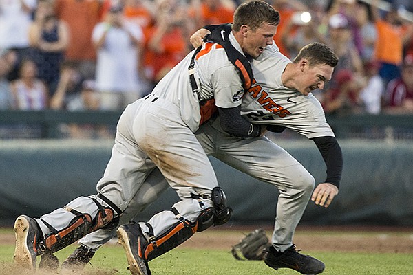 Oregon State catcher Adley Rutschman tackles pitcher Kevin Abel after recording the final out of the College World Series championship against Arkansas on Thursday, June 28, 2018, in Omaha, Neb.