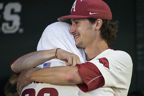 Arkansas pitcher Blaine Knight, facing, hugs catcher Grant Koch after the Razorbacks lost to Oregon State in the College World Series championship game on Thursday, June, 28, 2018, in Omaha, Neb.