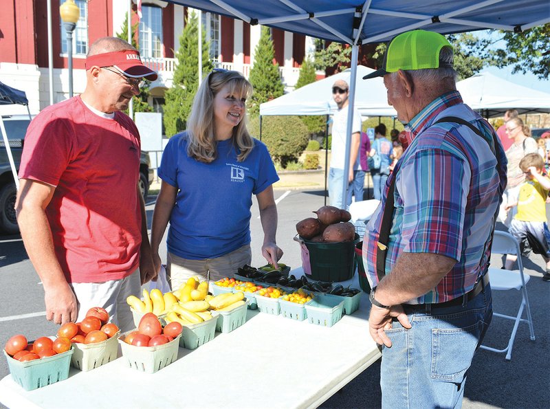 Scott, left, and Terri Riley shop at farmer David McCann’s booth at the Searcy Certified Farmers’ Market.