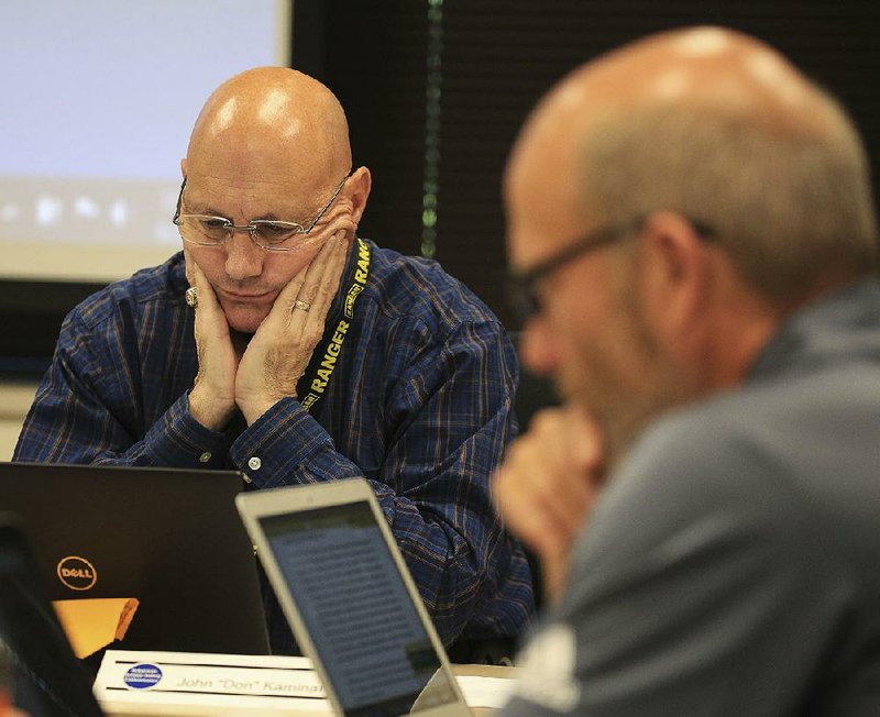 John “Don” Kaminar (left) and John Allison of the Arkansas School Safety Commission read through the panel’s preliminary report during a meeting Thursday in Little Rock.  
