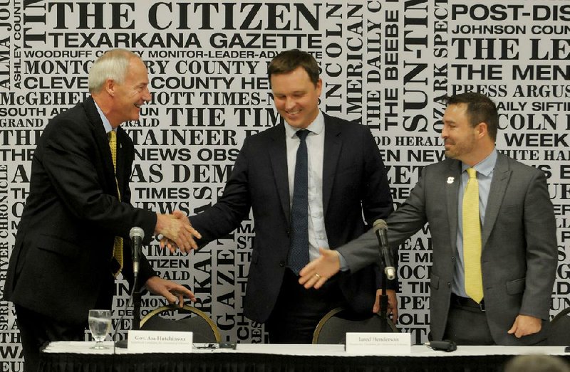 Gov. Asa Hutchinson greets gubernatorial challengers Jared Henderson (center), the Democratic candidate, and Libertarian candidate Mark West before the start of their debate Friday during the Arkansas Press Association convention in Eureka Springs.  