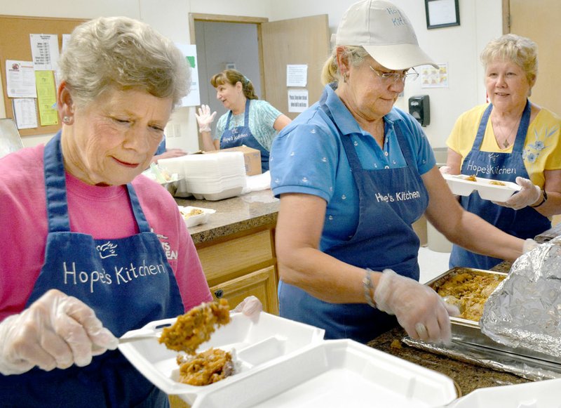 Janelle Jessen/Siloam Sunday Volunteers, from left, Judy Blank, Georgia Loyd and Maryette Womack made plates of food at Hope's Kitchen.
