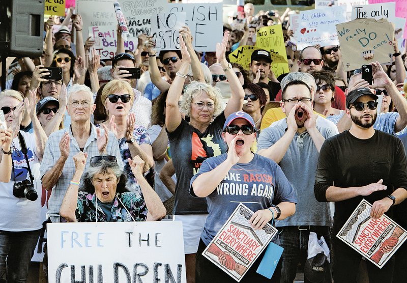 A crowd cheers during a rally Saturday at the downtown square in Fayetteville. The rally in Fayetteville is one of hundreds of rallies planned as part of a Families Belong Together national day of action to protest President Donald Trump's administration's zero-tolerance immigration policy. Advocacy groups such as MoveOn, the Human Rights Campaign and the American Civil Liberties Union have joined in, and at least 130 rallies in 48 states are planned.