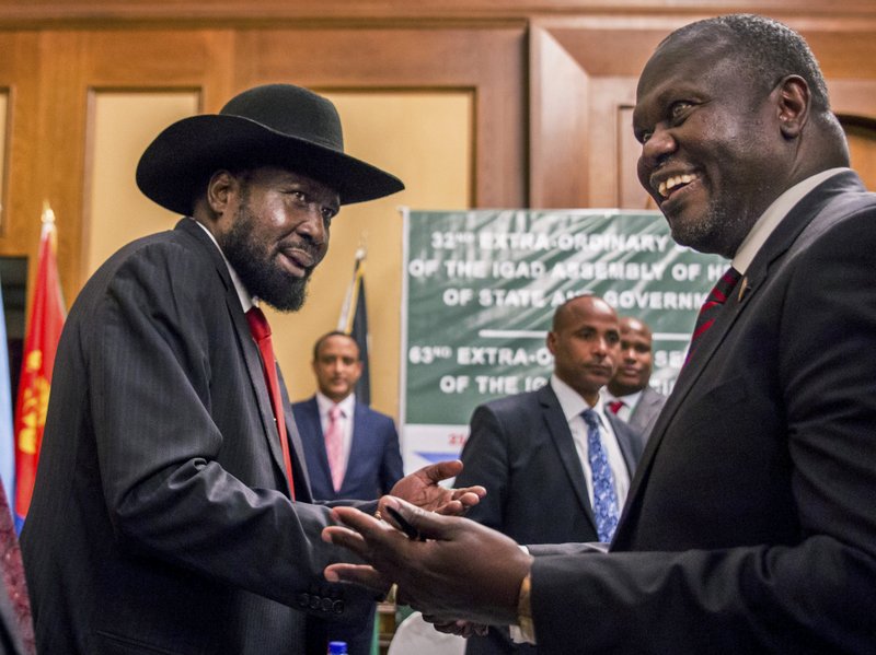 FILE - In this file photo dated Thursday, June 21, 2018, South Sudan's President Salva Kiir, left, and opposition leader Riek Machar, right, shake hands during peace talks in Addis Ababa, Ethiopia.  (AP Photo/Mulugeta Ayene, FILE)