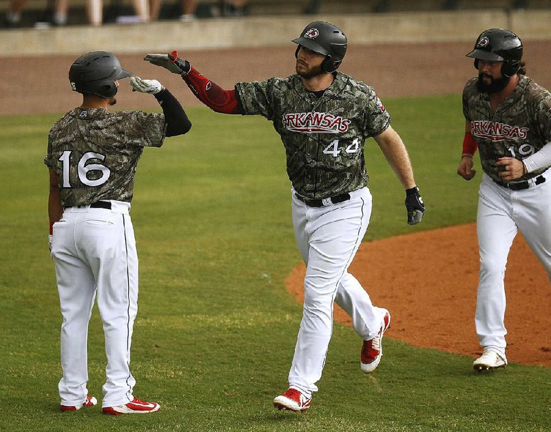 The Arkansas Travelers’ Joey Curletta (right) is congratulated by teammate Chris Mariscal after Curletta’s two-run home run in the fourth inning Sunday at Dickey-Stephens Park in North Little Rock. The Travelers won 3-1. Arkansas Democrat-Gazette/THOMAS METTHE 