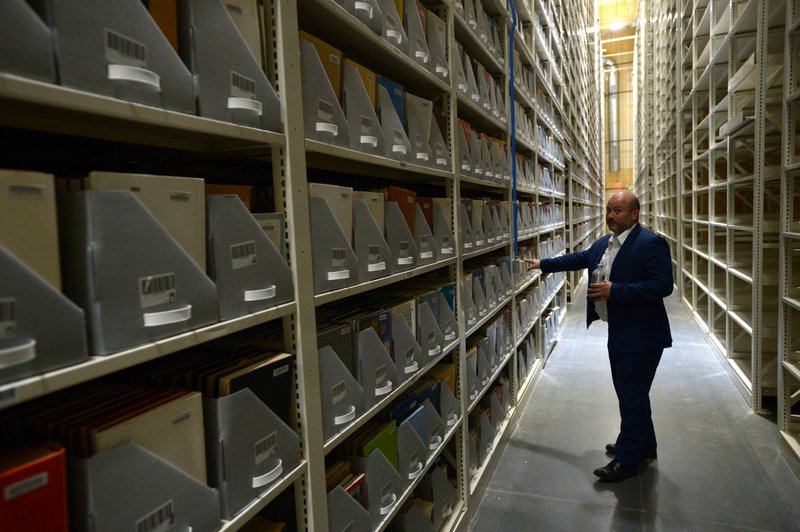 NWA Democrat-Gazette/ANDY SHUPE Marco De Prosperis, assistant dean of finance and administration at the University of Arkansas, explains Friday the archival and catalog system in a storage facility south of Martin Luther King Jr. Boulevard in Fayetteville. The proper place for books in a space-starved library at the University of Arkansas, Fayetteville has become the subject of some debate after an email sent to faculty by an outgoing librarian urging them to fight against changes that are removing roughly two-thirds of printed materials.