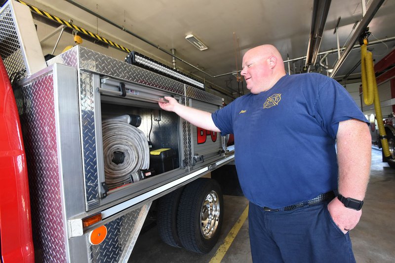 NWA Democrat-Gazette/FLIP PUTTHOFF Rogers firefighter Moose Dunavan shows equipment carried in fire engines at Fire Station No. 6 on Bellview Road. A new fire station is proposed to better serve the city's west side.