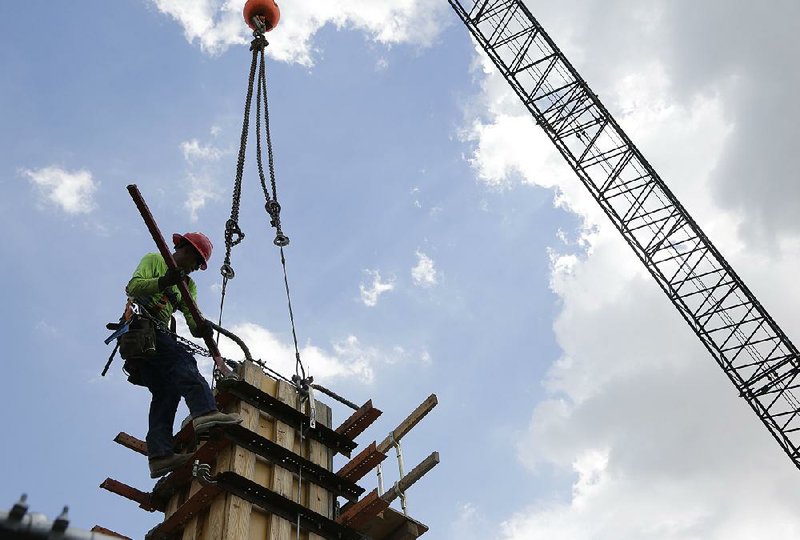 A construction crew works on the site of a mixed-use project that will feature apartments, retail, a hotel and cafes in Coral Gables, Fla., in this April photo. (AP Photo/Lynne Sladky, File)