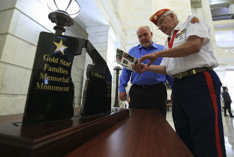 Paul Garrett (right), co-chairman of a committee hoping to build a monument to honor Gold Star families, talks Tuesday with Greg Williams, chief executive officer of Nabholz construction company in Conway, at the state Capitol.  