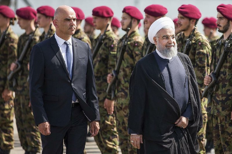 Swiss Federal Council President Alain Berset and Iranian President Hassan Rouhani review an honor guard Monday in Zurich. Rouhani said if the U.S. gets its allies to stop buying Iranian oil, that could also jeopardize Mideast oil exports.  