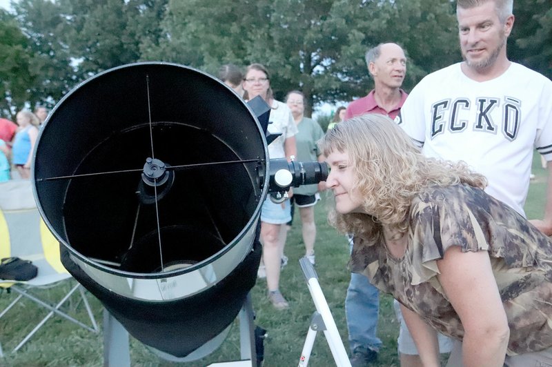 LYNN KUTTER ENTERPRISE-LEADER Melissa Hoffman of Prairie Grove looks through one of the telescopes set up for a Star Party at Prairie Grove Battlefield State Park.