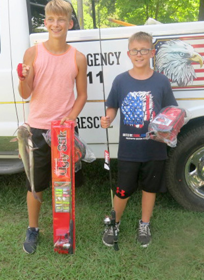 Westside Eagle Observer/SUSAN HOLLAND Brothers Hunter and Evan Carter, sons of Joe and Sheri Carter, display their fish and the prizes they won in the Sulphur Day fishing derby. Both were first-place winners in their age groups. Hunter, 13, took the 12-16 age division with a 16 1/4-inch fish; and Evan, 11, won the 6-11 age division with a 16 3/4-inch fish. Their prize tackle boxes and Ugly Stik rods were furnished by the Arkansas Game and Fish Commission.