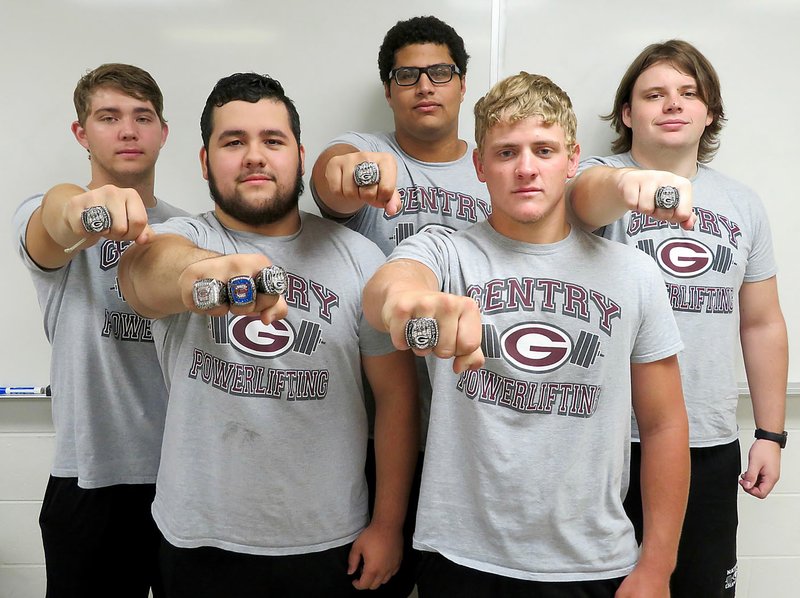 Westside Eagle Observer/RANDY MOLL Gentry High School students Tanner Christie, Tomas Gomez, Kerlose Ruzek, Konner Hodges and J.T. Crosby show their powerlifting championship rings on Friday. Not pictured ring recipients are Gavin Taylor, Lawrence Caro, Mason Clark and Khang Yang. They are coached by Sean Seligman.