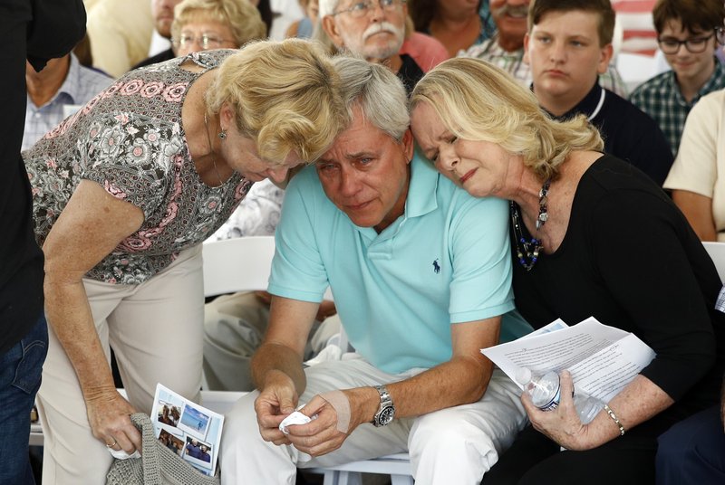 IN MOURNING: Carl Hiaasen, center, brother of Rob Hiaasen, one of the journalists killed in the shooting at The Capital Gazette newspaper offices, is consoled by his sisters Barb, left, and Judy during a memorial service, Monday, July 2, 2018, in Owings Mills, Md.