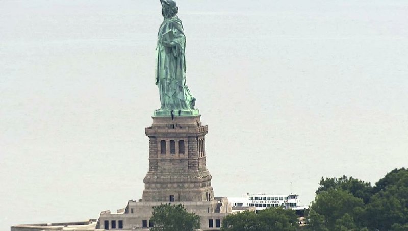 People climb Wednesday on the pedestal of the Statue of Liberty in New York Harbor.  