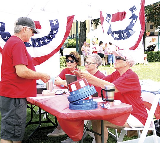 The Sentinel-Record/Beth Reed PATRIOTIC PICNIC: Steven Parker, left, buys a ticket for lunch from volunteer Coni Hall, right. Hall, as well as Kay Fischer and Sarah MaGee, volunteered during for the inaugural Red, White &amp; You Picnic in the Park on Arlington Lawn Wednesday, hosted by Friends of Hot Springs National Park. Donations and proceeds will go toward restoration of the Maurice Bath House.