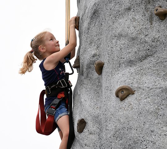 The Sentinel-Record/Grace Brown- Lindsey Jackson, 7, climbs the free standing rock wall at Oaklawn Racing and Gaming's 4th of July event, Spa Blast, on Tuesday, July 3, 2018. 