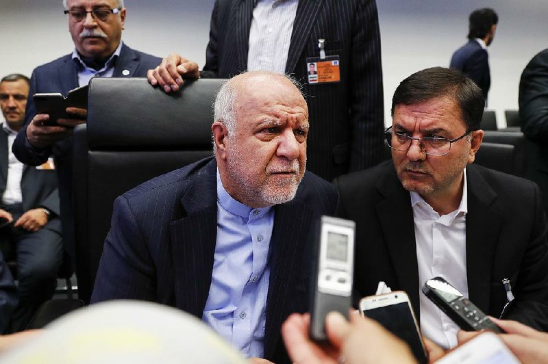 Bijan Namdar Zanganeh, Iran’s oil minister (left), speaks to reporters last month at OPEC’s meeting in Vienna, where members agreed to boost production. 