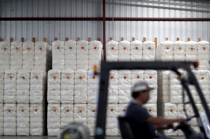 In this June 21, 2018, photo, bales of cotton sit packed and labeled while waiting to be shipped from the South Central Georgia Gin Company in Enigma, Ga. The company estimates that 40-50 percent of the cotton processed at the gin is exported out of the country, China being one of the main recipients. (AP Photo/David Goldman)